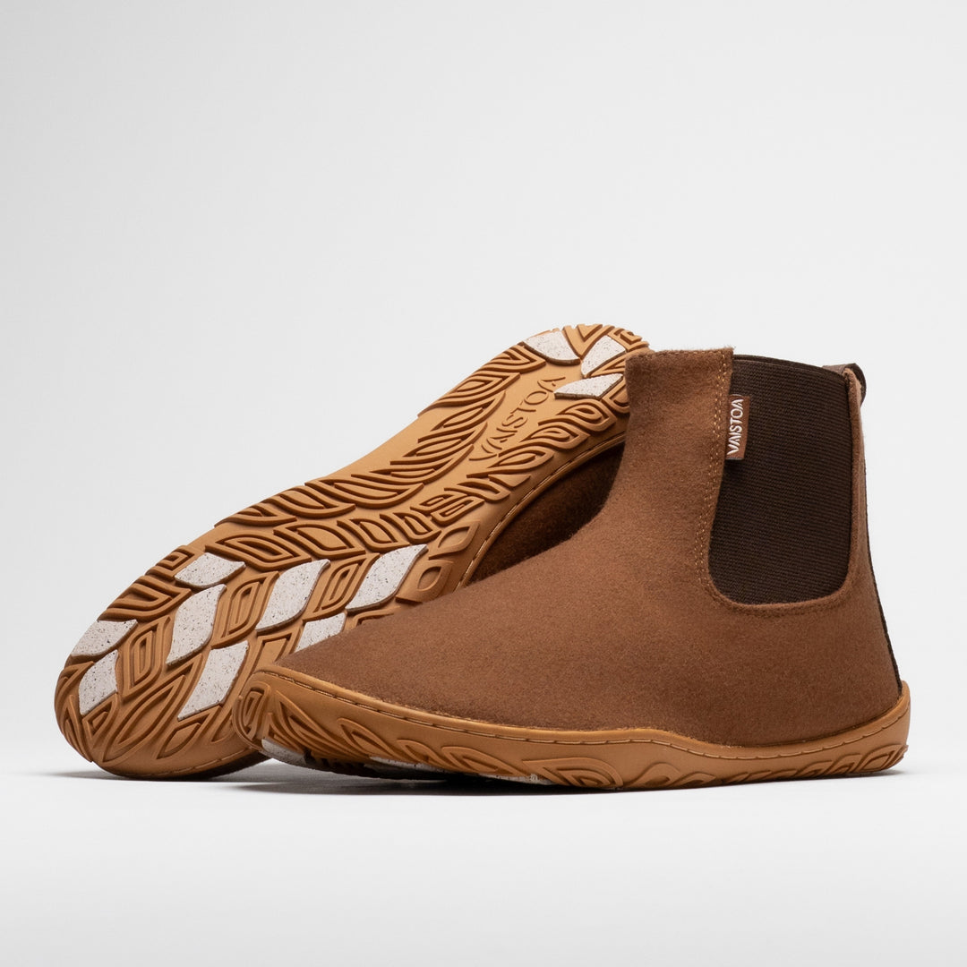 Vaistoa Sulo 2 winter barefoot chelsea boots – pair with the front shoe showing the elastic panel side and the second shoe leaning against its shaft with the outsole facing the camera, showing the tread pattern and grip pads
