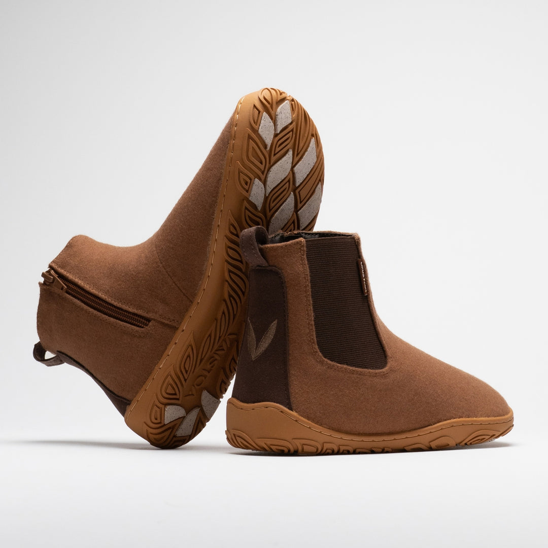 Vaistoa Sulo 2 winter barefoot chelsea boots – pair with one shoe tilted on its side showing the zipper and the grip pads on the outsole and the other standing next to it with the Vaistoa leaf symbol on the heel