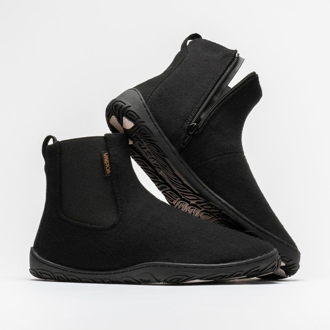 Vaistoa Sulo 2 winter barefoot chelsea boots – pair with the front shoe shown from the side with the elastic panel and the second shoe leaning against its shaft, showing the zipper and the edge of the outsole