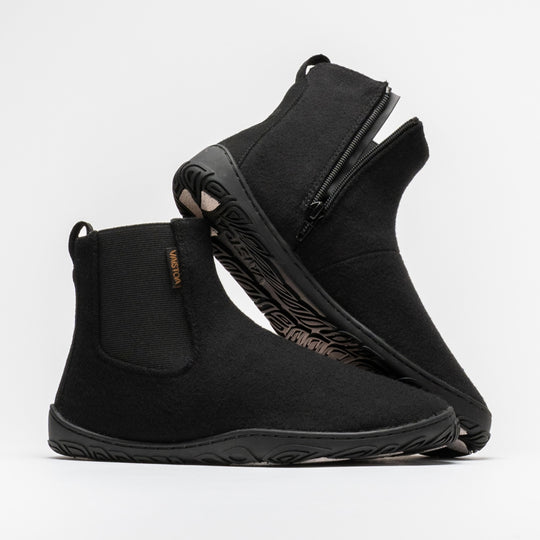 Vaistoa Sulo 2 winter barefoot chelsea boots – pair with the front shoe shown from the side with the elastic panel and the second shoe leaning against its shaft, showing the zipper and the edge of the outsole