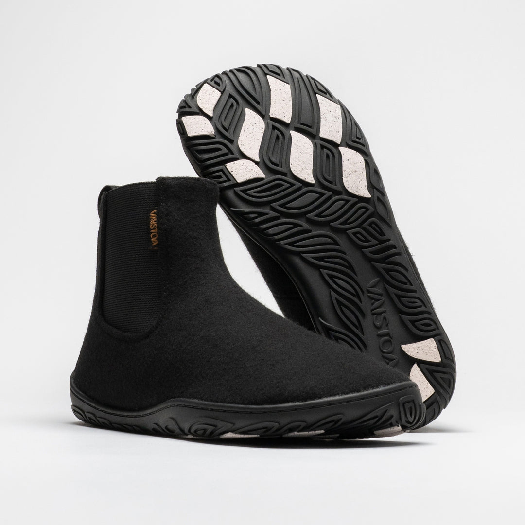 Vaistoa Sulo 2 winter barefoot chelsea boots – pair with one shoe standing with the elastic panel visible and the other leaning behind it with the outsole facing the camera, the Vaistoa logo and grip pads shown large