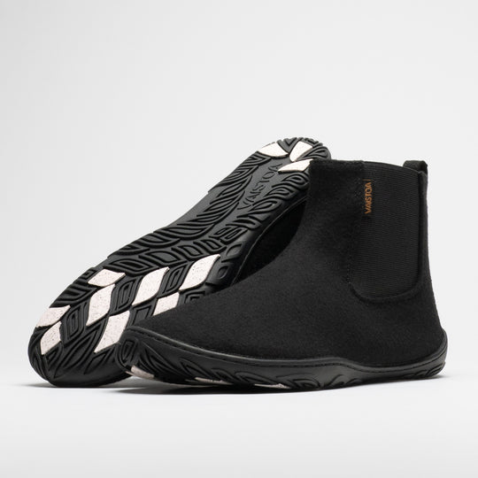 Vaistoa Sulo 2 winter barefoot chelsea boots – pair with the front shoe showing the elastic panel side and the second shoe leaning against its shaft with the outsole facing the camera, showing the tread pattern and grip pads