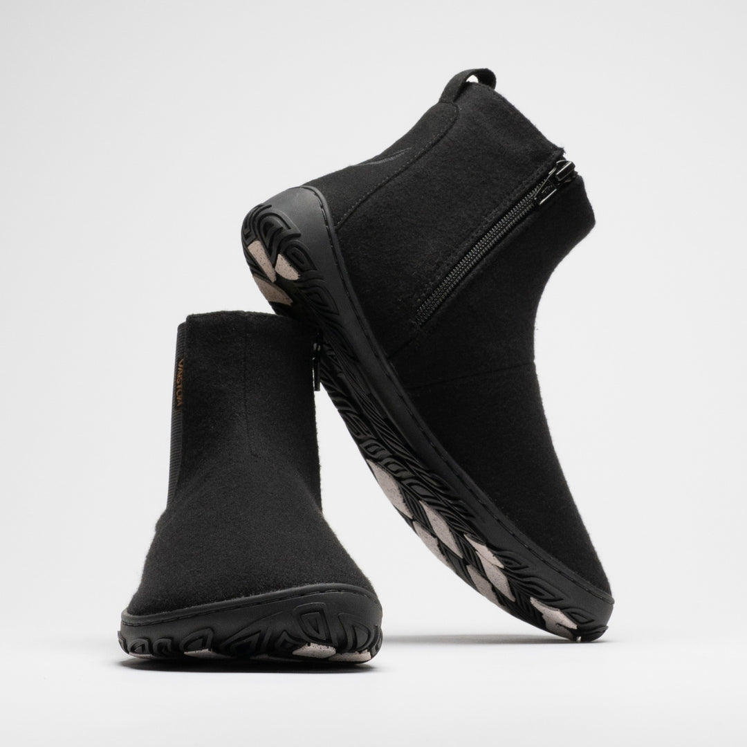 Vaistoa Sulo 2 winter barefoot chelsea boots – pair with the front shoe shown from a front angle and the second shoe leaning against its shaft, showing the zipper and the grip pads on the outsole