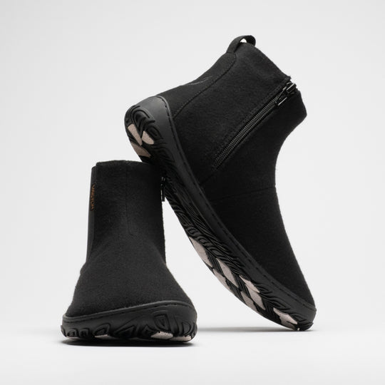Vaistoa Sulo 2 winter barefoot chelsea boots – pair with the front shoe shown from a front angle and the second shoe leaning against its shaft, showing the zipper and the grip pads on the outsole