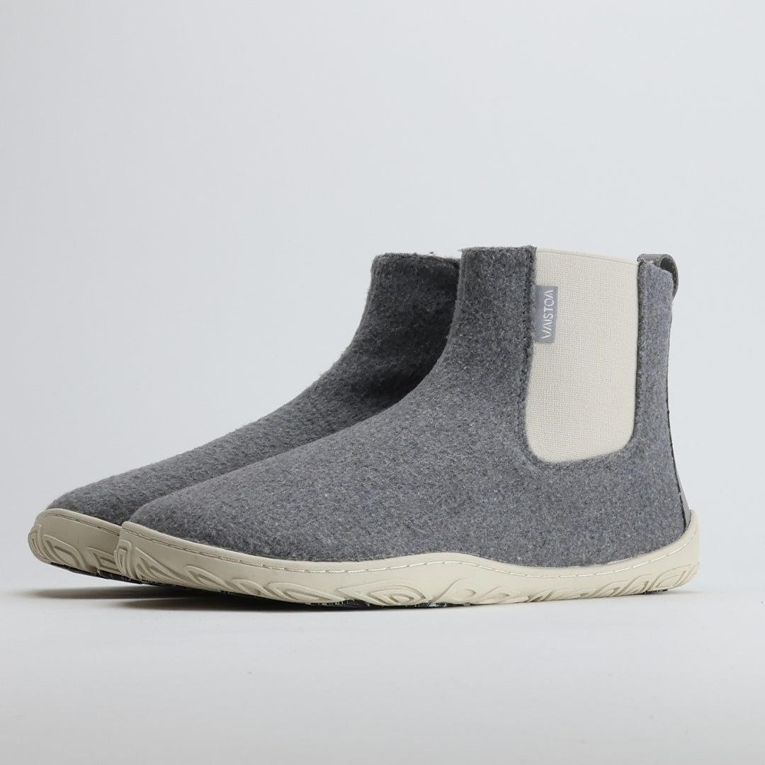 Pair of pearl grey barefoot winter felt Chelsea boots shown from a front angle on a light gray background, highlighting their soft felt upper, warm lining, and minimalist Nordic design.