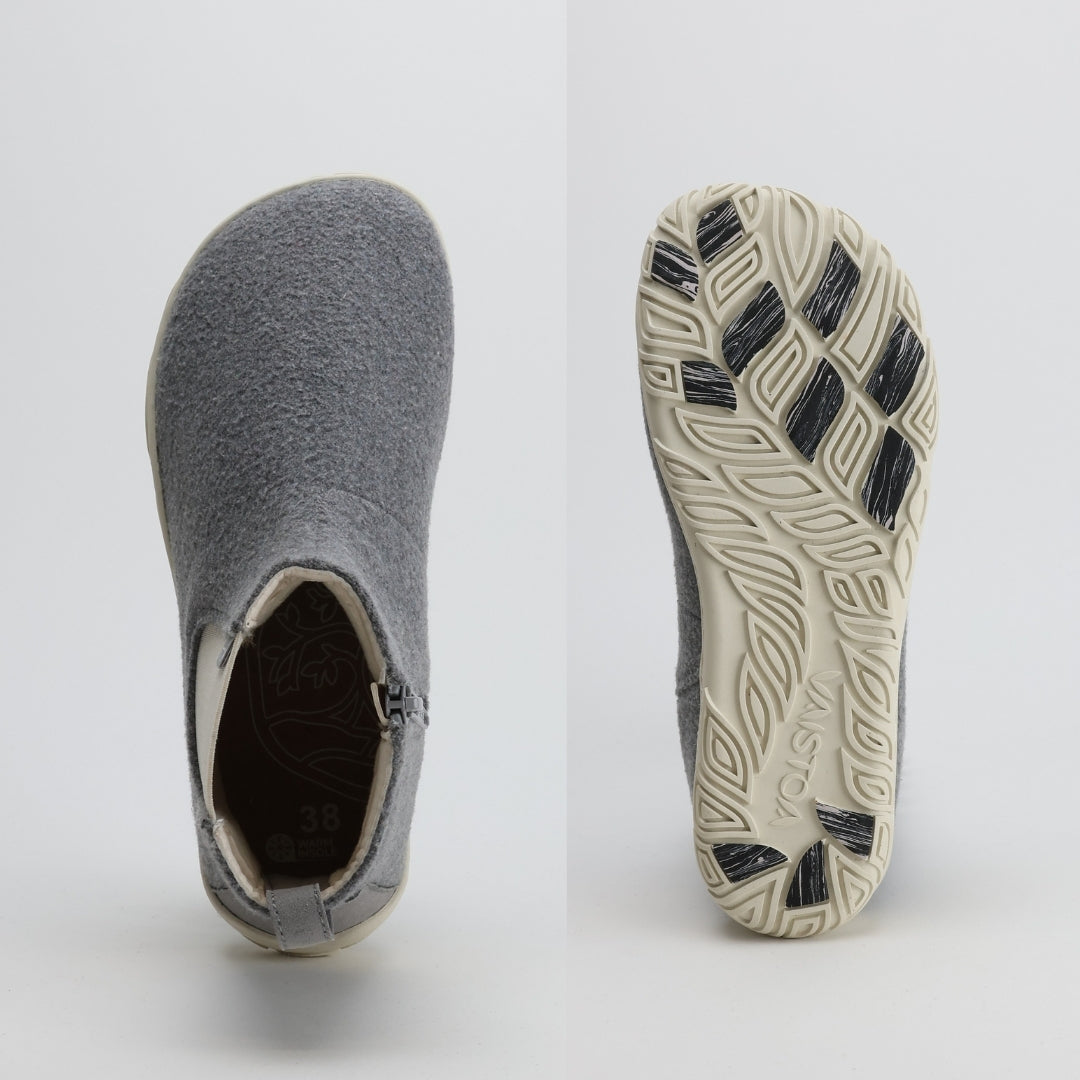 Kuva ylhäältä ja alhaalta päin helmenharmaasta Vaistoa Sulo -huopanilkkurista. Kuvassa korostuu kengän leveä, jalan anatomiaa myötäilevä varvastila sekä Vaistoa Pitoa™ -talvipohjan kuviointi ja pitopalat.