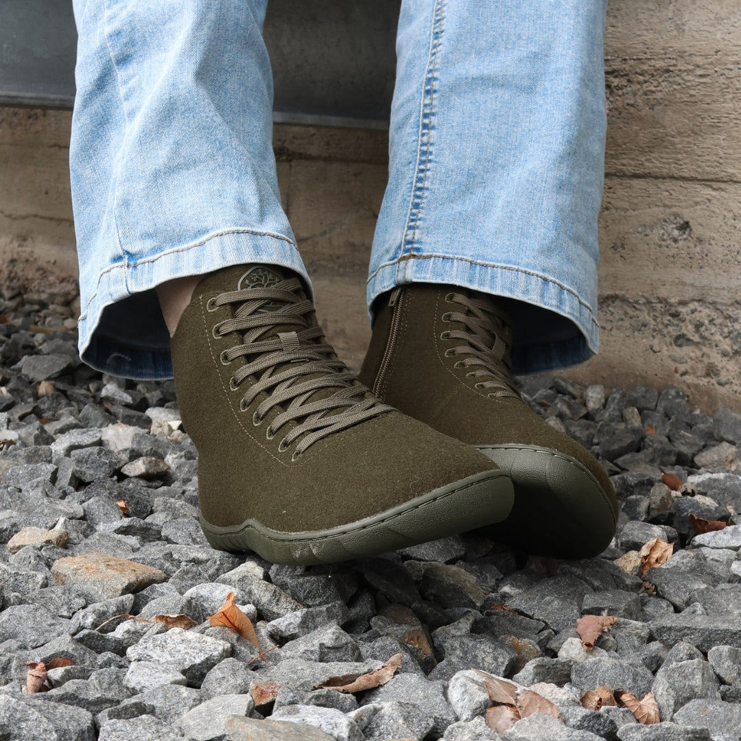 Vaistoa Tunto 2 felt barefoot sneakers – on-foot, dark trousers, seated on gravel, front view, olive colour