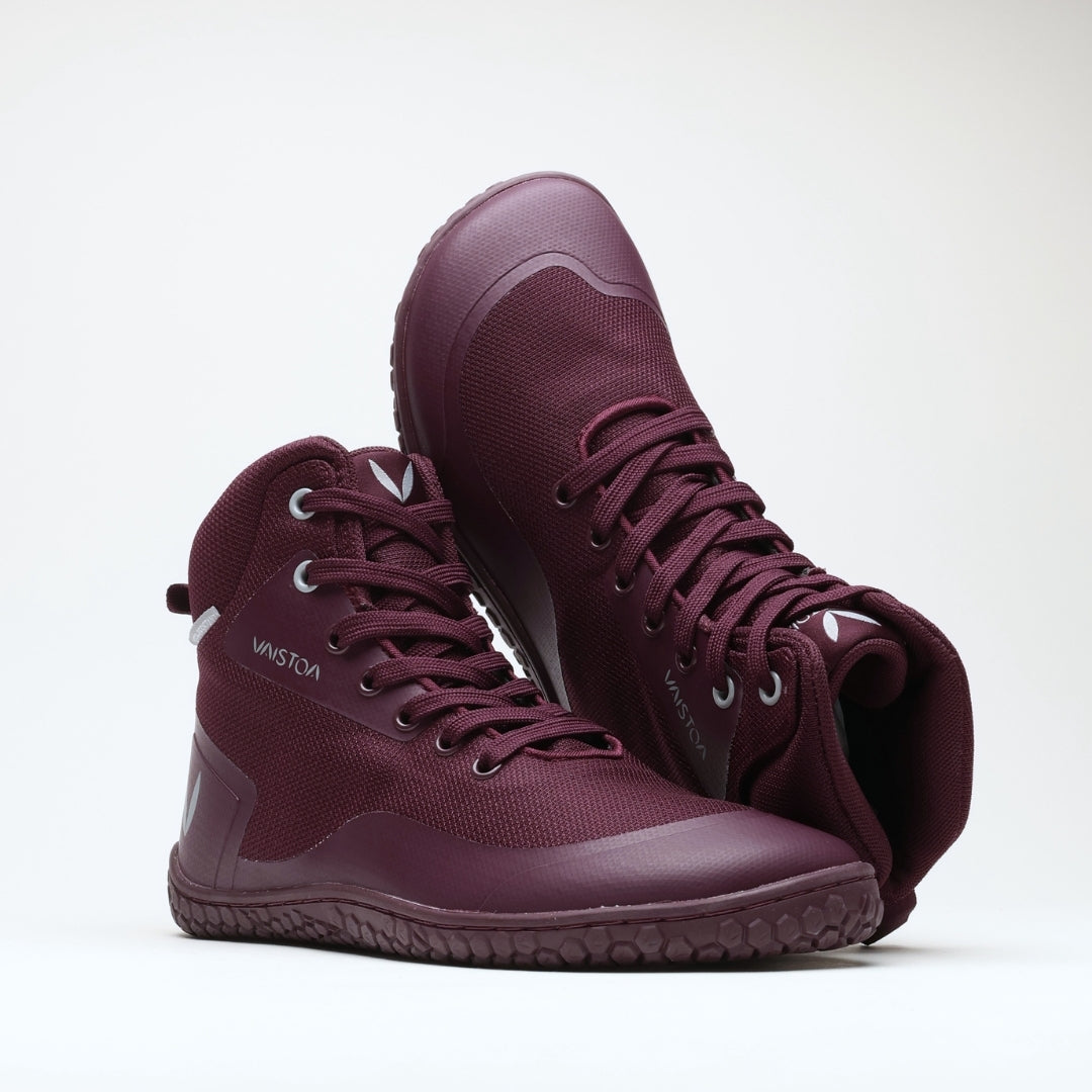 Vaistoa Tuohi 2 barefoot light hiking shoes burgundy – one shoe standing and the other resting against its shaft with the toe raised at an angle and the open collar facing the camera