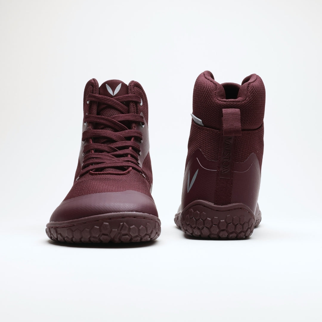 Vaistoa Tuohi 2 barefoot light hiking shoes burgundy – two shoes standing upright, the one on the left from the front and the one on the right from behind, with the heel loop and the Vaistoa name embossed on the heel counter visible