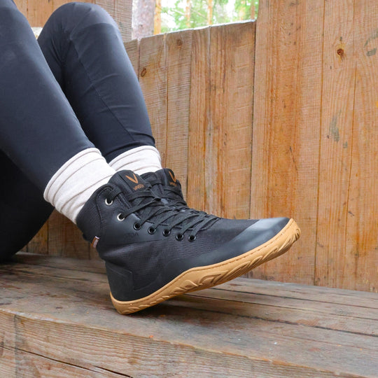 Vaistoa Tuohi barefoot trekking shoes black – lifestyle photo, spring, sitting on a bench at a fire shelter