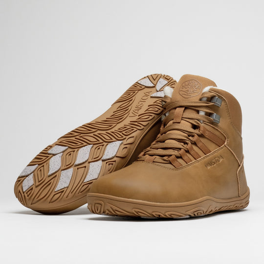 Vaistoa Uoma 4 winter barefoot trekking boots – pair with one shoe lying with the outsole facing the camera showing the light grip pads and the other standing in front of it at a front angle, against a light background