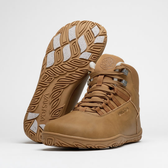 Vaistoa Uoma 4 winter barefoot trekking boots – pair with one shoe leaning against the shaft of the standing shoe with the outsole facing the camera, showing the Vaistoa logo and grip pads