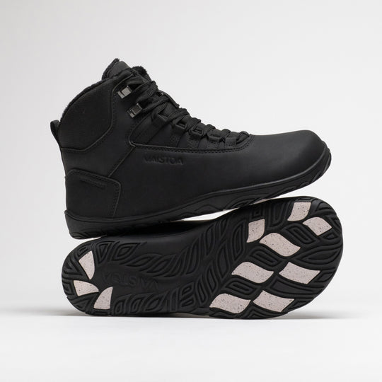 Vaistoa Uoma 4 winter barefoot trekking boots – one shoe standing on top of the other shoe's outsole, with the Vaistoa logo and grip pads visible on the outsole below