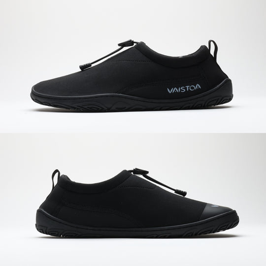 Black Vaistoa Vire barefoot shoe shown from the side profile against a light background. The flat, zero drop outsole without heel elevation is clearly visible, illustrating the natural barefoot shoe structure.